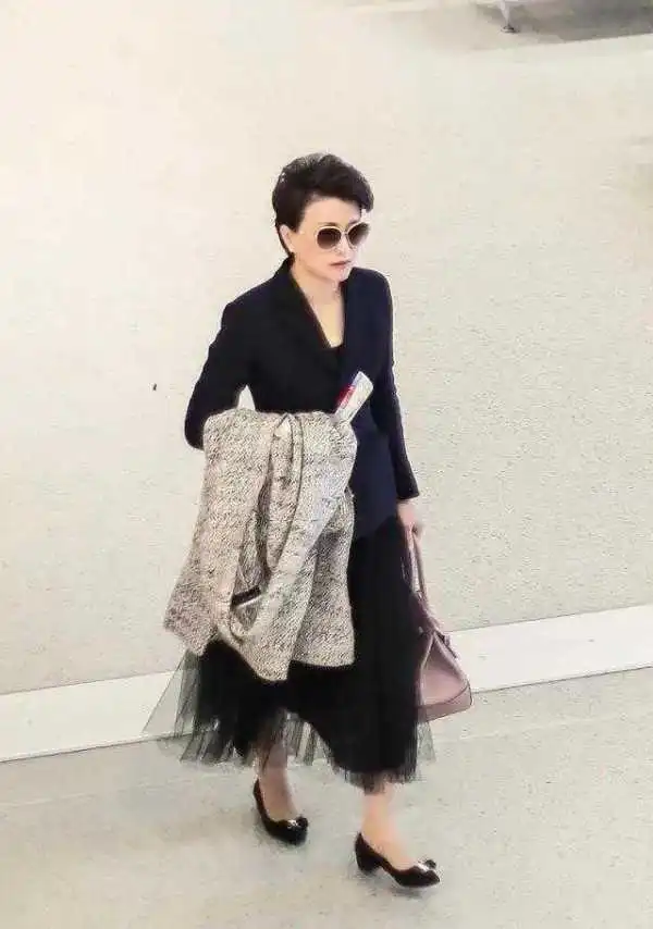 杨澜走机场都这么精致,穿西装配纱裙气质高雅大气,诗书气质出众